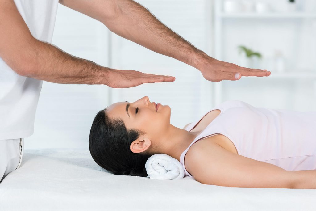 reiki london healer putting hands above body